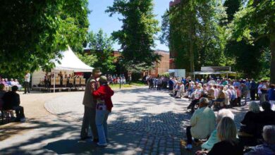 Viele Menschen tanzen zum Pfingskonzert im Bernauer Stadtpark. Im Hintergrund spielt eine Band